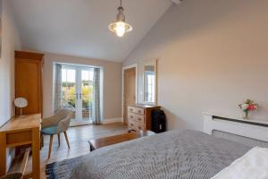 a bedroom with a bed and a desk and a dresser at The Garden House in Low Catton 
