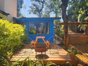 Cerro Gordo的住宿－Granero de Las Joyas, Valle de Bravo，庭院设有两把椅子和一张桌子,还有一间房子