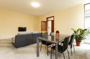 een woonkamer met een tafel en een bank bij La casa azzurra in San Giorgio Di Mantova