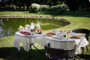 un tavolo con cibo sopra accanto a uno stagno di La Aguada Hotel Boutique a San Rafael