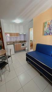 Habitación con cama azul y cocina. en Apartamentos Boulevard, en Caldas Novas