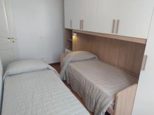 Twee aparte bedden in een kleine kamer met ermottermottermott bij San Rocco Appartamenti 2 - Appartamento IL CASTAGNO in Asciano Pisano