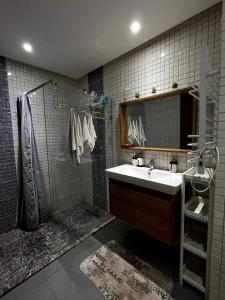 La salle de bains est pourvue d'un lavabo et d'une douche. dans l'établissement Appartemment 3 pièces à Harhoura, à Harhoura