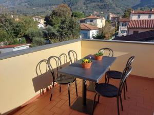 een tafel en stoelen op een balkon met uitzicht bij San Rocco Appartamenti 2 - Appartamento IL CASTAGNO in Asciano Pisano