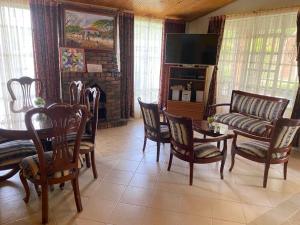 ein Wohnzimmer mit einem Sofa, einem Tisch und Stühlen in der Unterkunft Cabañas Villa del Dorado in Paipa