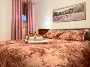 Baredinka Izola في إيزولا: غرفة نوم مع سرير كبير مع لحاف وردي