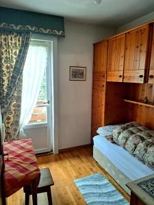 um quarto com uma cama e uma janela em luminoso ed accogliente, centralissimo appartamento indipendente em Cortina dʼAmpezzo