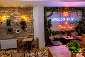 イスタンブールにあるAPOLLO HOTEL & APARTMENtSの壁に看板を掲げたテーブル付きレストラン