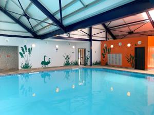 a large indoor pool with a large blue swimming pool at Lodge at Chichester Lakeside 2 Bed in Chichester