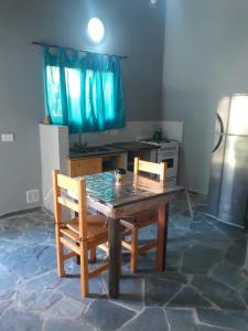 eine Küche mit einem Holztisch und 2 Stühlen in der Unterkunft La casita de Pablo in Santa Teresita