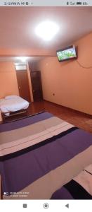 sypialnia z łóżkiem i telewizorem na ścianie w obiekcie Casa Chicama w mieście Puerto Chicama