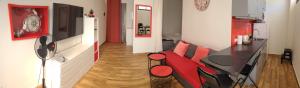 a living room with a red couch and a table at La Arena studio in Puerto de Santiago