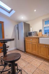 a kitchen with a refrigerator and a table and chairs at 176 Marrell in Helmsdale