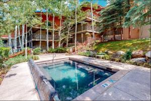 a swimming pool in front of a house at Enclave 108, Snowmass Ski-In Ski-Out Condo with Shared Pool, Hot Tub & Gym in Snowmass Village