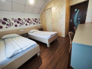 クルジュ・ナポカにあるCasa Thomas Clujのベッド2台とテーブルが備わる客室です。