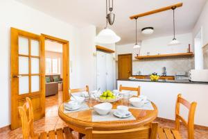 uma cozinha e sala de jantar com uma mesa de madeira e cadeiras em Villa Biniparrell by Villa Plus em Biniparrell