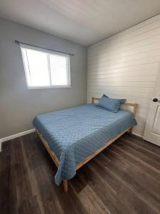1 dormitorio con 1 cama con edredón azul y ventana en Your Saint Louis home, en Benton