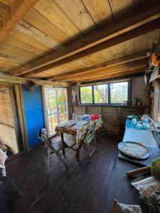 una habitación con mesas y sillas en una cabaña en Mirando el Mar, en Barra de Valizas