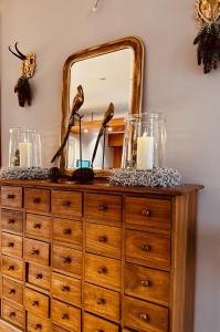 a dresser with a mirror and candles on it at Landhotel Bellevue in Wolfshausen