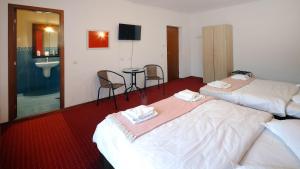 um quarto de hotel com duas camas e uma mesa e cadeiras em Pensiunea Montan din Bran,sat Simon SPA indoor em Bran