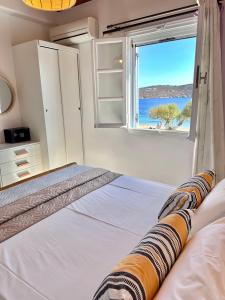 1 dormitorio con 1 cama y vistas al océano en Galazio Seaside Apartments, en Livadakia