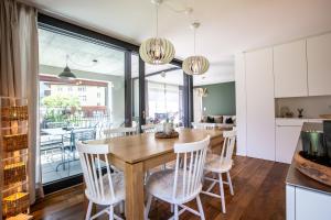 cocina y comedor con mesa de madera y sillas en Haus Burgermeister Wohnung Erzhorn, en Arosa