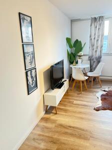 uma sala de estar com uma televisão e uma mesa em Kölner City Apartment direkt am Zentrum Nähe Hbf em Colônia