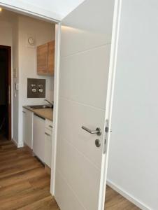 uma porta que leva a uma cozinha com armários brancos em Kölner City Apartment direkt am Zentrum Nähe Hbf em Colônia