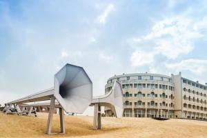 um edifício com uma escultura em frente a um edifício em Studio West-Ende em Middelkerke