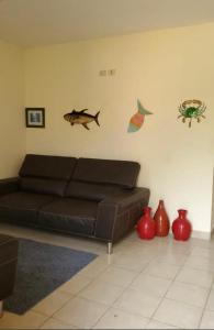 a living room with a brown couch and some vases at Casa en la playa puerto cortes in Puerto Cortes