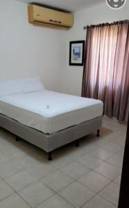 ein Schlafzimmer mit einem Bett in einem Zimmer in der Unterkunft Casa en la playa puerto cortes in Puerto Cortes