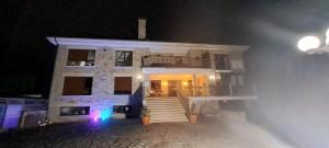 - un bâtiment blanc avec des escaliers devant lui la nuit dans l'établissement Casa Buda Conors, à Foz