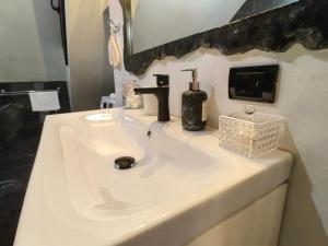 a bathroom with a white sink and a mirror at Alissa House in Borsa