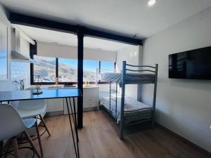 a room with a desk and a bunk bed and a kitchen at Apartamentos Sierra Nevada BlueTTravel - Zona baja in Sierra Nevada