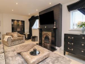 a living room with a fireplace and a tv at Damson Cottage in Poulton le Fylde