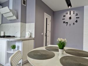 cocina con mesa y reloj en la pared en Premium apartment on Belvedere, en Ivano-Frankivsk