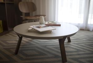 a coffee table with a book and glasses on it at Somewhere - Estoril Guesthouse in Estoril