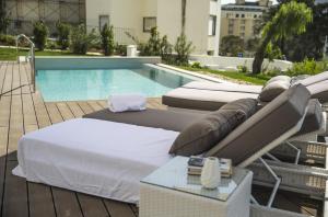 a group of beds sitting next to a swimming pool at Somewhere - Estoril Guesthouse in Estoril