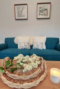 a living room with a blue couch with a basket of flowers at The Garden Cottage of Warren Lodge boutique cottages in Dromod