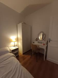 - une chambre avec un lit et un bureau avec un miroir dans l'établissement Josef appartment, à Paris