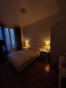 - une chambre avec un lit, une fenêtre et 2 lampes dans l'établissement Josef appartment, à Paris