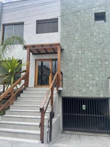 una casa con una escalera que conduce a una puerta en Flat em Juquehy, en São Sebastião