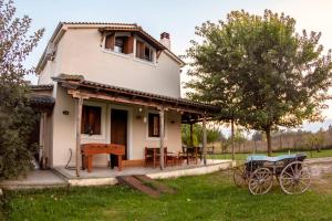 a small white house with a table and a bench at Το σπίτι στο αγρόκτημα in Droserón