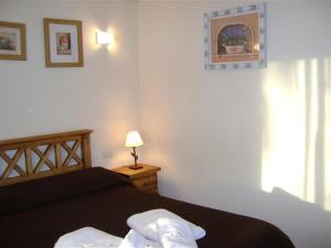 una camera con letto, lampada e finestra di Carilo Princess a Carilo