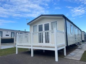 mały domek siedzi na przyczepie w obiekcie Seaside Escape at Trecco Bay w mieście Porthcawl