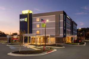 卡尔霍恩Home2 Suites By Hilton Calhoun的停车场内有旗帜的大建筑