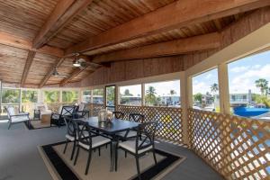 a screened porch with tables and chairs and windows at Bay Therapy in Key Largo