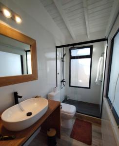 uma casa de banho com um lavatório, um WC e um espelho. em Las Rochas, Suites de Mar em Punta Del Diablo