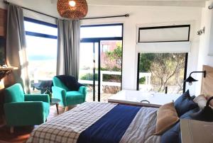 um quarto com uma cama, uma banheira e uma janela em Las Rochas, Suites de Mar em Punta Del Diablo