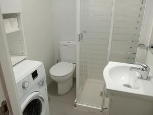 ein weißes Bad mit einem WC und einer Waschmaschine in der Unterkunft Apartamento la Soledad, junto al Alcázar in Toledo
